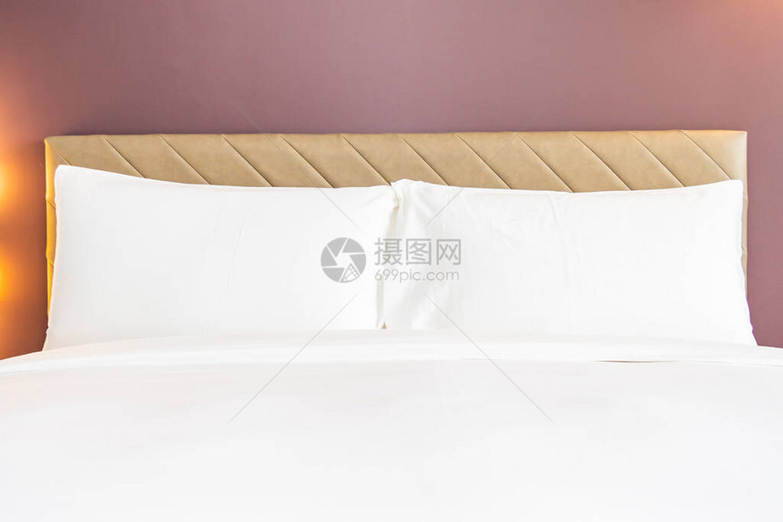白色舒适的枕头和床铺毯子图片