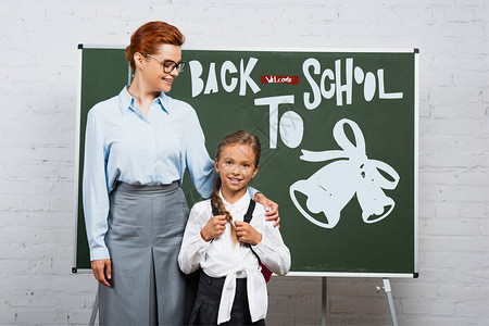 老师和女学生站在黑板旁边背图片