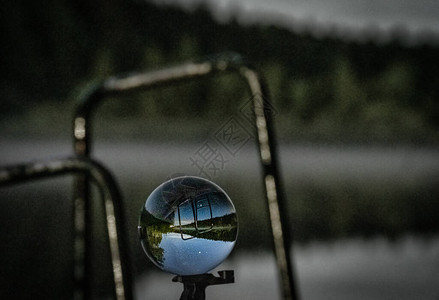 在湖和背景森林前以一个小透镜球图片