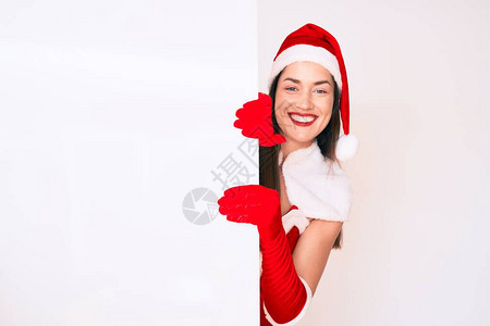 身穿圣诞老人服装的年轻女子举着空白的空横幅图片