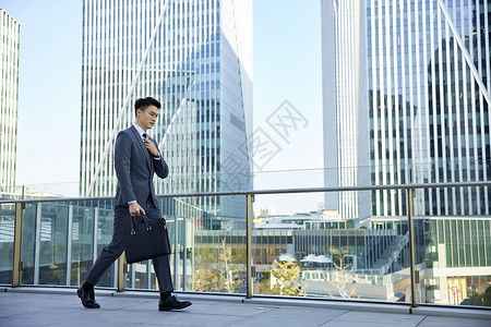 商务男性上班路上整理领带背景图片