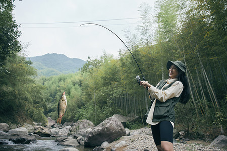 青年女性溪流钓鱼背景图片