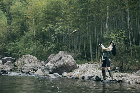 年轻女性溪边钓鱼高清图片