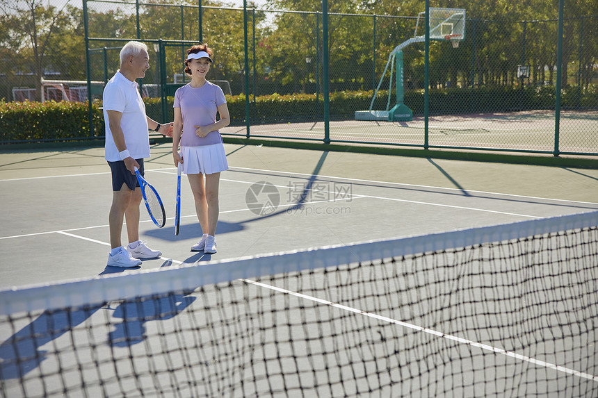 网球场交流沟通的老年夫妻图片