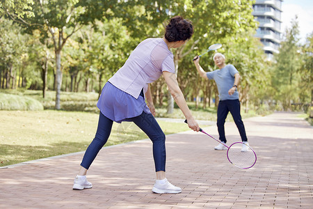 老年人在公园老年夫妇在公园打羽毛球背景