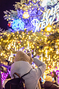 圣诞浪漫铃铛圈圣诞新年集市上正在拍照的女生背影背景