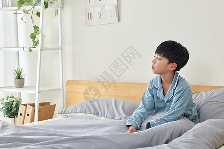坐在床上孤单的小男孩图片
