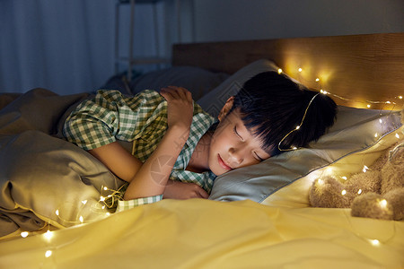温馨夜晚熟睡的小男孩背景图片
