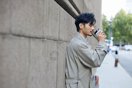 穿风衣的都市成熟男性街边喝咖啡高清图片