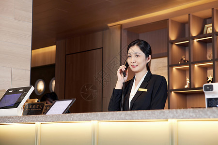 酒店前台接电话的女服务员背景图片