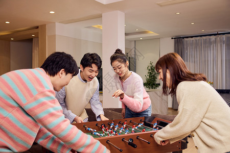 互动竞技青年男女聚会一起玩桌上足球背景