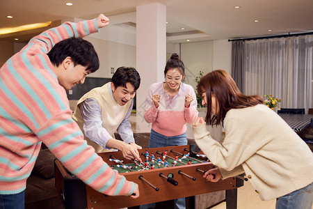 游戏男女一起玩桌上足球的青年男女背景
