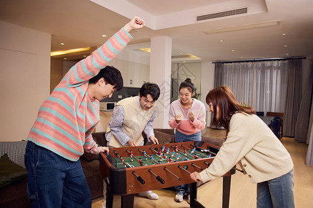互动竞技青年聚会一起玩桌上足球背景