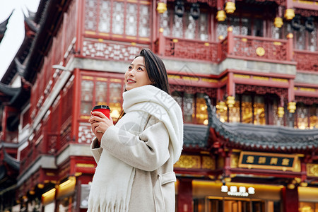 女子上街购物手捧咖啡的女子感受节日氛围背景