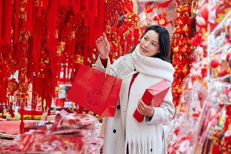 逛年货的青年女子手拿新年礼物盒图片