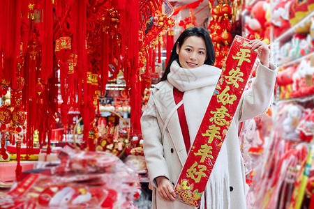 女子上街购物采购新年配饰的女子展示春联背景