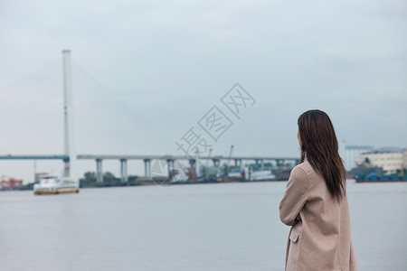 青年美女站在江边背影图片