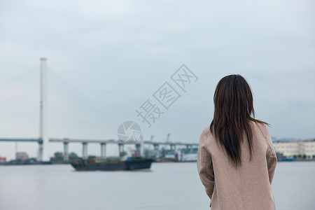 悲伤逆流成河文艺年轻美女站在江边背影背景