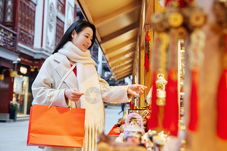 挂饰灯笼逛庙会的青年美女够买新年挂饰背景