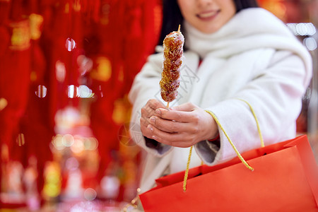 味儿春节女性手拿糖葫芦特写背景