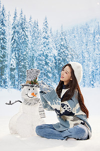 与雪人互动的冬日甜美女孩图片