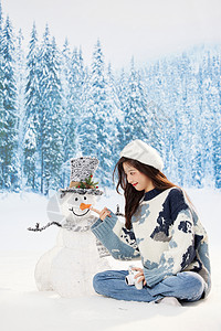 与雪人互动的冬日甜美女孩图片