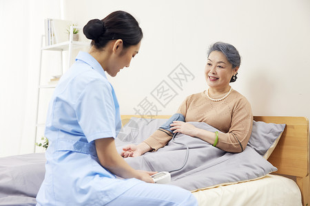 关爱妇女护工帮老年患者测量血压背景