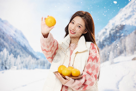 手捧橘子的冬日美女背景图片