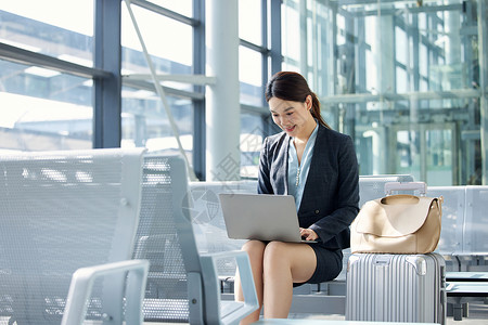 飞女商务女性机场出行使用电脑背景