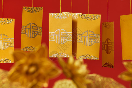 黄色福猪年贺卡烫金荷花树枝上的金色红包特写背景