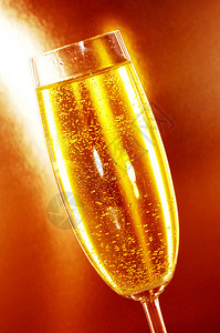 橙色背景中的一杯香槟图片