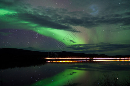 夜天星云和北极光在加拿大育空地区湖岸的乡背景图片