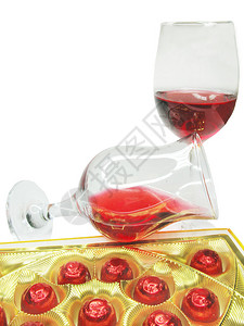 玻璃酒杯中的红葡萄酒和巧克力糖果图片