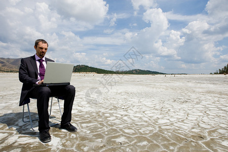 现代商人在外边笔记本电脑上打字的照片图片
