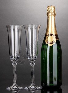 灰色背景中的一瓶香槟和高脚杯图片