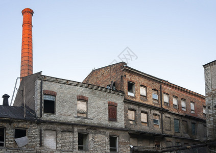 废弃的旧工业建筑和高大的红砖烟囱图片