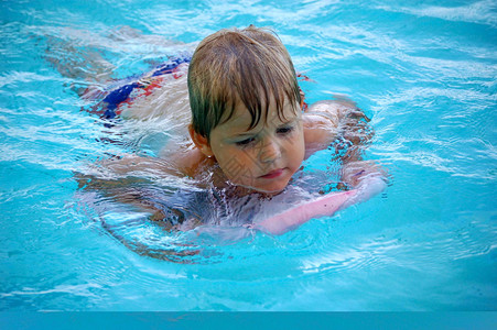 一个小男孩学游泳先用踢图片