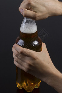 一个男人在桌子上打开一瓶啤酒图片
