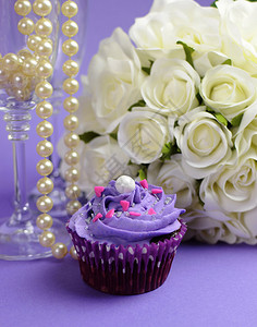 白玫瑰的婚礼花束紫蛋糕和珍珠在香槟杯中图片