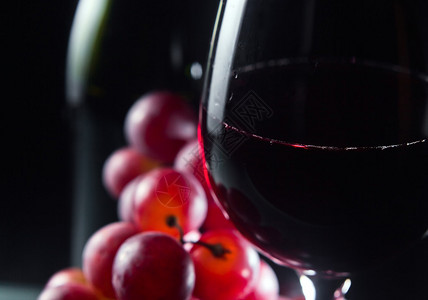 葡萄和葡萄玻璃黑色背景的红葡萄酒图片