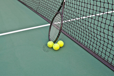有球拍和球的网球场图片
