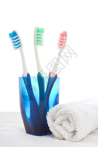 蓝色玻璃牙刷和白色毛巾图片