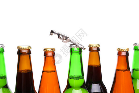 顶瓶啤酒和白色背景上的开瓶器图片