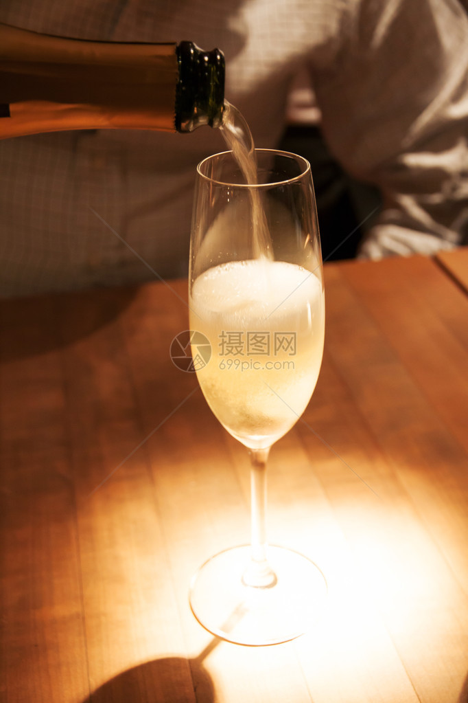 庆祝活动男人将白葡萄酒倒入玻璃杯中图片