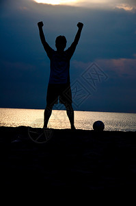 沙滩上踢足球的人剪影图片
