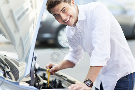 微笑的男子检查汽车背景图片