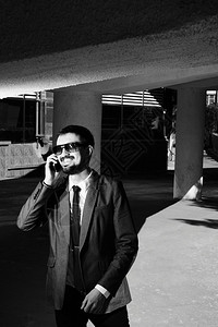 一个微笑的商人在电话上讲话的图片