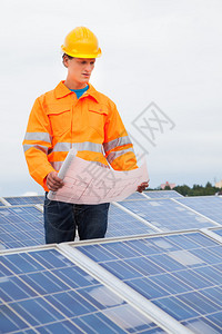 一名男工程师用太阳能电池板贴着蓝色图片