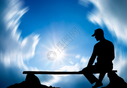 这个人坐在长椅上背对着天空图片