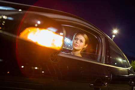 晚上开车漂亮的年轻女人晚上在城市里驾驶现代汽车图片